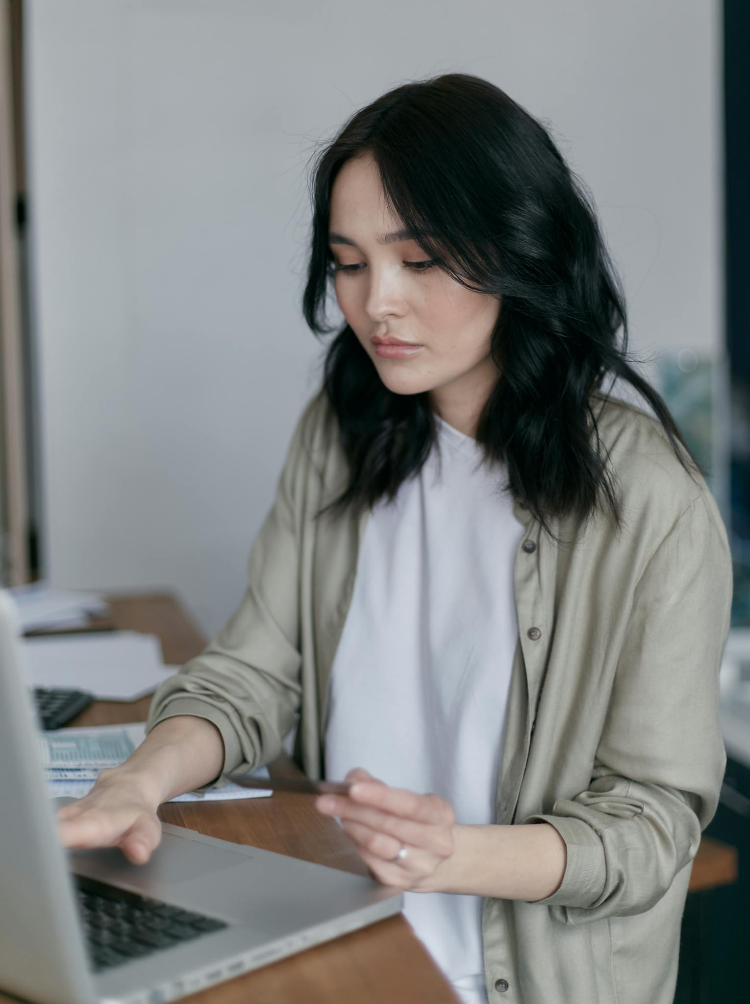 Home Focused Young Woman Working On A Laptop At Her Desk Managing Finances. 6964340 1530x2048